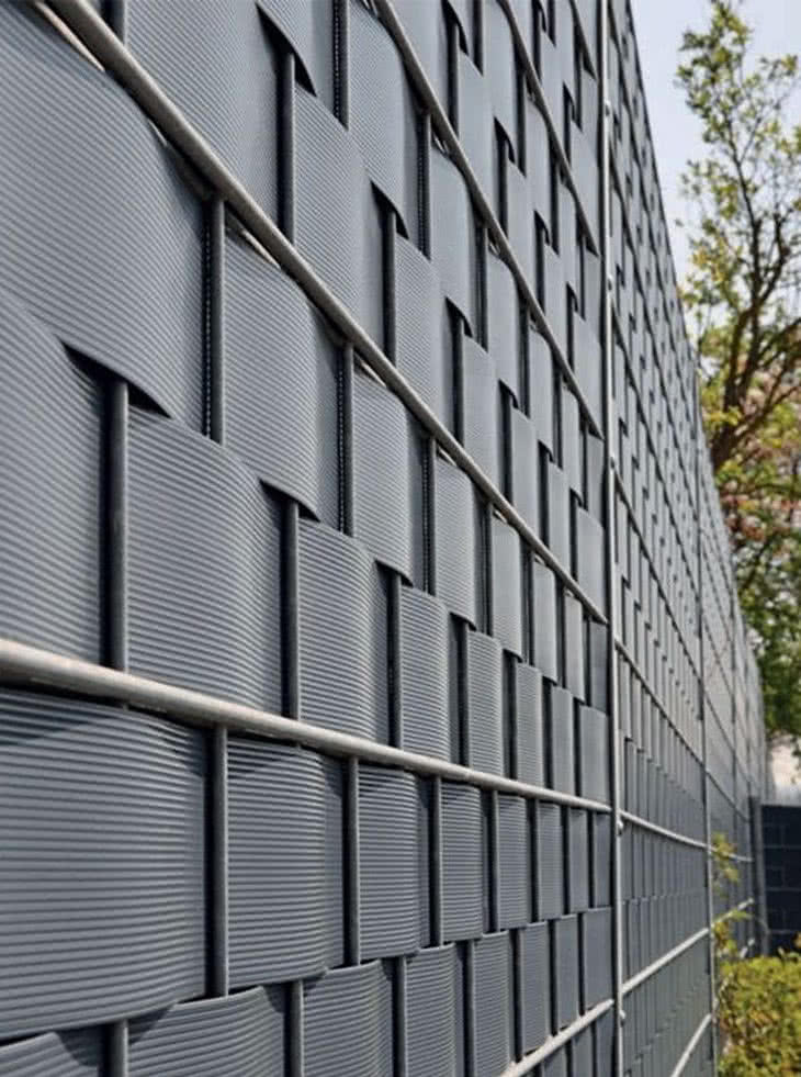 Ogrodzenie metalowe: specjalne taśmy, które przeplata się między drutami, w celu zapewnienia ogrodzeniu szczelności Ogrodzenie metalowe: specjalne taśmy, które przeplata się między drutami, w celu zapewnienia ogrodzeniu szczelności